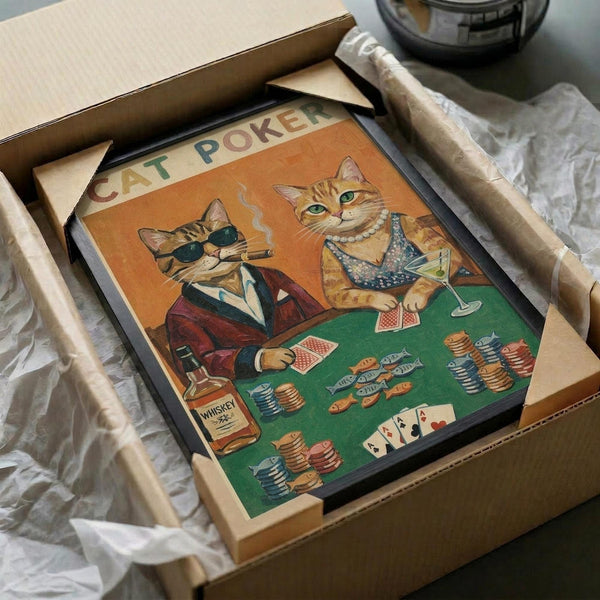 May include: Vintage-style poster print featuring two anthropomorphic orange tabby cats playing poker at a green felt table. One cat wears sunglasses and smokes a cigar, while the other wears a pearl necklace and holds a martini glass. The scene shows poker chips, playing cards, and a whiskey bottle on the table. The artwork has warm orange and green tones in a retro illustration style, shown framed in black and packed in a cardboard shipping box with protective wrapping paper.