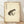 May include: Framed poster print featuring a spotted frog in Japanese ink wash painting style on aged cream paper with black Chinese characters and red seal stamps, displayed in light wood frame leaning against white wall on wooden floor with soft natural lighting and shadows