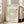 May include: Framed beige poster with black text arranged in a spiral pattern around a vinyl record icon, displayed on wooden floor against white wall next to beige upholstered chair near bright windows with natural lighting streaming in
