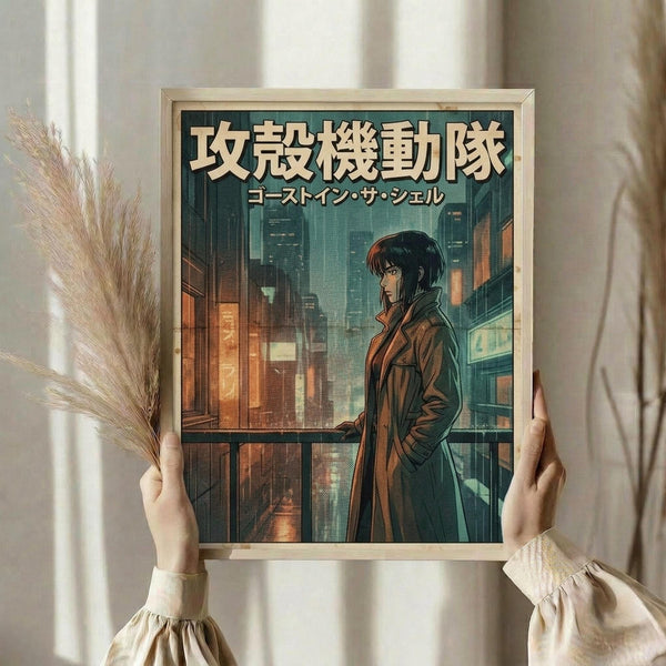 May include: Hands holding a framed anime-style poster featuring a woman with dark hair in a brown coat standing on a balcony overlooking a cyberpunk cityscape at night. The artwork has Japanese text at the top and shows glowing windows and neon lights in the background. The poster is displayed in a light wooden frame against white curtains, with dried pampas grass visible on the left side.