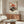 May include: Vintage-style Japanese poster featuring red turntable with vinyl record against orange sunset backdrop, displayed above mid-century walnut credenza in modern living room with white sculptural chair, glass coffee table, and floor lamp