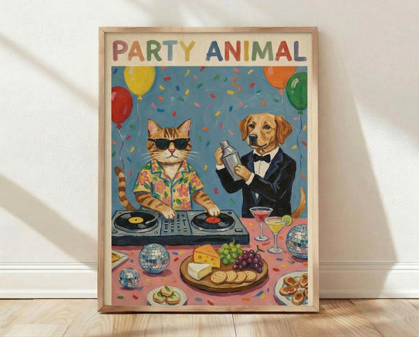 May include: Framed poster print leaning against white wall on light wood floor. Artwork shows cartoon cat DJ wearing sunglasses and floral shirt at turntables, golden retriever bartender in black tuxedo making cocktails. Colorful confetti and balloons fill blue background. Party spread includes cheese board, appetizers, disco balls, and cocktail glasses on pink surface below.