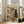 May include: Framed poster print leaning against white wall next to beige sofa in bright living room. Artwork shows brown dog wearing sunglasses and paint-splattered smock holding palette and brush, painting at easel with black cat wearing beret sitting nearby. Wine bottle labeled "Vin Rouge Chat" and cheese visible on floor. Colorful text reads "ART CRITIC" at top. Vintage-style illustration with warm tones in light wood frame.