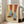 May include: Framed artwork showing legs wearing orange and yellow striped tights with light blue ribbed socks and brown textured heels with ankle ties, displayed on wooden floor against white wall next to beige upholstered chair in bright room with windows
