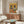 May include: Colorful poster featuring two French bulldogs in Mexican attire at a festive table with tacos, guacamole, and tequila bottles on yellow background, displayed above a mid-century modern walnut credenza in a contemporary living room with white curved chair and glass coffee table.