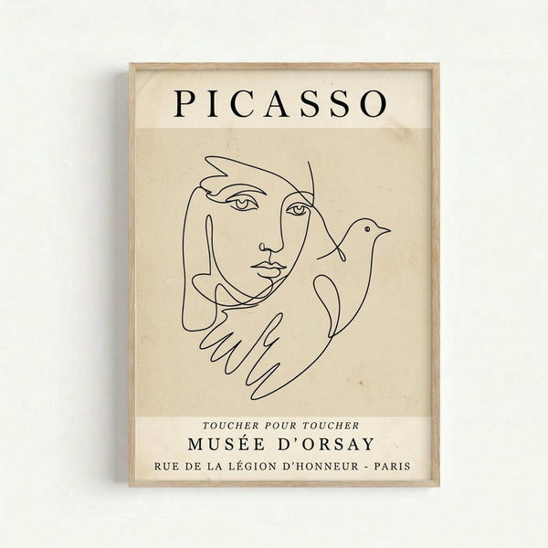 Framed beige poster featuring a minimalist black line drawing in Picasso's style showing a face with hands holding a dove. The artwork includes "PICASSO" at the top and "TOUCHER POUR TOUCHER MUSÉE D'ORSAY RUE DE LA LÉGION D'HONNEUR - PARIS" text at the bottom. The poster is displayed in a light wood frame against a white wall, with subtle shadow casting to the left.