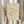 May include: Person in cream sweater holding framed beige poster featuring black line drawing of woman's face with hands holding dove, dried pampas grass visible to left, white curtained window background, natural wood frame