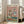 May include: Framed poster showing two white ducks in sunglasses doing yoga poses on colorful mats. One duck wears a straw hat and floral shirt, the other a striped shirt while balancing a wine glass. Pink background with "DUCK YOGA" text in multicolored letters. Yoga props scattered on green floor. Light wood frame leaning against beige chair in bright, modern living room with large windows.