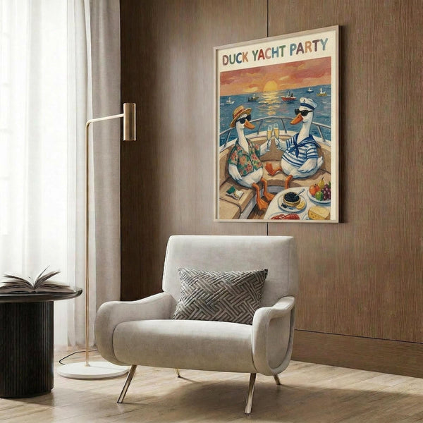 May include: Framed poster hanging on wood-paneled wall above beige upholstered armchair with geometric pillow. Artwork shows two cartoon ducks in sunglasses on yacht deck at sunset - one in floral shirt, one in striped sailor outfit, toasting with champagne glasses. Caviar and appetizers on table. Modern floor lamp and side table with open book visible in styled room setting.