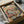 May include: Vintage-style poster print in black frame showing orange tabby cat in blue striped pajamas napping in brown leather armchair. Another cat in suit reads nearby. Colorful "CAT NAP" text at top. Framed artwork packed in cardboard box with protective wrapping on white surface.