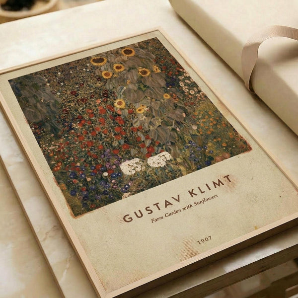 Vintage art print poster featuring Gustav Klimt's colorful floral garden painting with sunflowers, wildflowers, and rich earth tones in an ornate decorative style. The cream-colored poster shows "GUSTAV KLIMT" text below the artwork with "Farm Garden with Sunflowers" and "1907" details. Print lies flat on white bedding next to a white ceramic vase, displaying the museum-quality reproduction with visible paper texture and classic exhibition poster formatting.