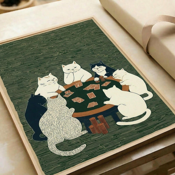 May include: Green woodblock-style print showing five cats playing poker around a wooden table with red playing cards and poker chips scattered on top. The cats are rendered in white, black, and striped patterns against a textured green background with fine horizontal lines. The artwork is displayed flat on white paper with a light wooden frame border, positioned next to a white cylindrical object on what appears to be a light wooden surface.