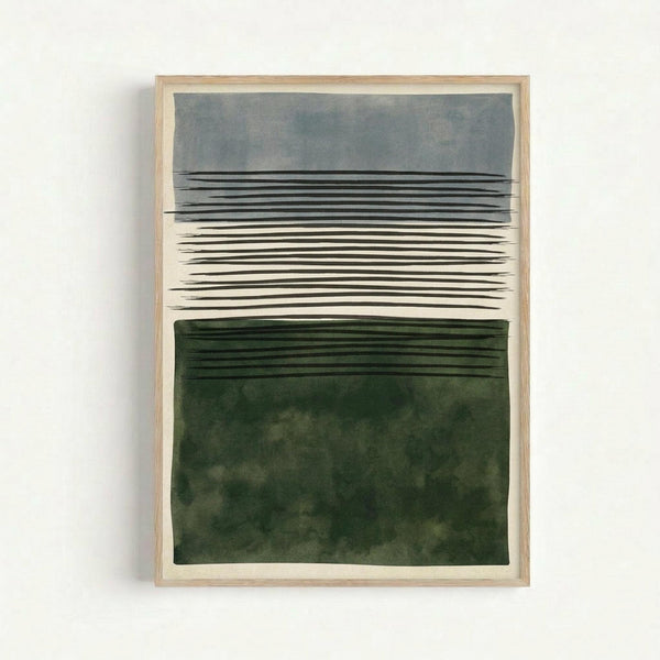 A framed abstract artwork featuring horizontal black lines across the center between two color blocks - a soft gray-blue watercolor wash at the top and a deep forest green watercolor section at the bottom. The piece is displayed in a light wood frame against a white wall, creating a minimalist landscape-inspired composition with organic, flowing brushwork textures.