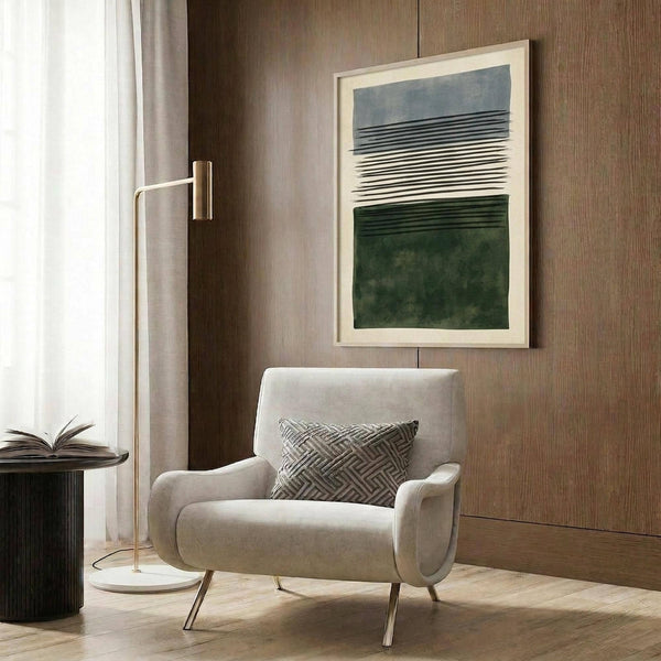 May include: Modern minimalist abstract art print with blue, white, and green horizontal bands and linear details, displayed in light wood frame on warm wood paneled wall above cream upholstered armchair with geometric pillow, brass floor lamp, and dark round side table with open book in contemporary living room setting