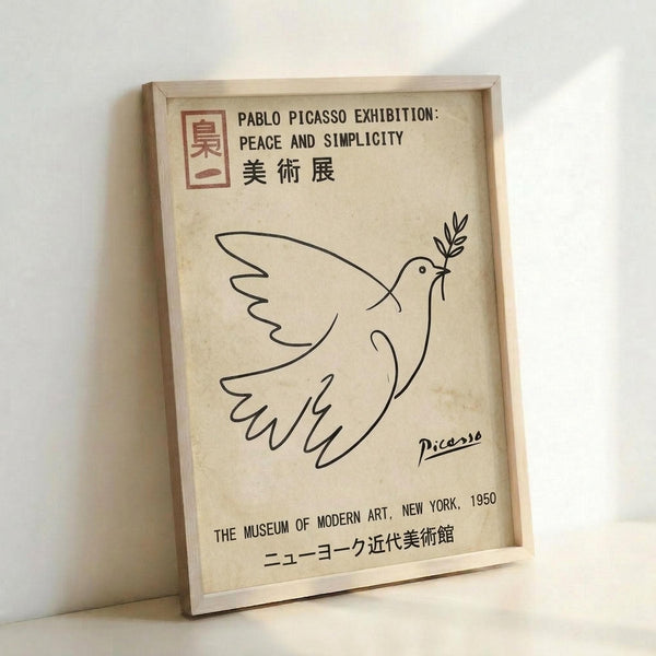 A cream-colored exhibition poster featuring Picasso's minimalist line drawing of a dove carrying an olive branch in its beak. The poster displays text for a Pablo Picasso exhibition titled "Peace and Simplicity" at The Museum of Modern Art, New York, 1950, with Japanese characters and Picasso's signature visible. The artwork is displayed in a light wooden frame against a white wall, showing the poster's vintage, aged appearance with subtle texture and warm tones.