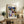 May include: Framed Paul Klee abstract art print displayed on rustic wooden sideboard in modern living room. Colorful geometric composition features overlapping shapes in blues, yellows, greens, and earth tones with Bauhaus exhibition text. Natural wood frame complements weathered furniture, fern plant, ceramic vase, and cream upholstered chair creating warm, contemporary interior styling.