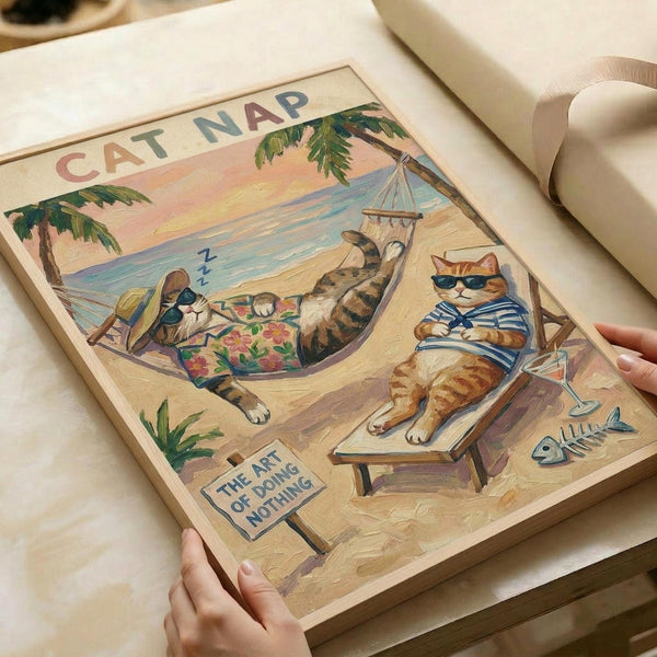 A vintage-style poster artwork showing two cats relaxing on a tropical beach. One tabby cat sleeps in a colorful floral hammock strung between palm trees, while an orange tabby wearing sunglasses and a striped shirt lounges on a wooden beach chair. The sandy beach scene includes a small sign reading "The Art of Doing Nothing," fish bones scattered nearby, and a sunset sky over blue ocean waves. The poster has a warm, retro illustration style with soft peachy and blue tones. Human hands hold the