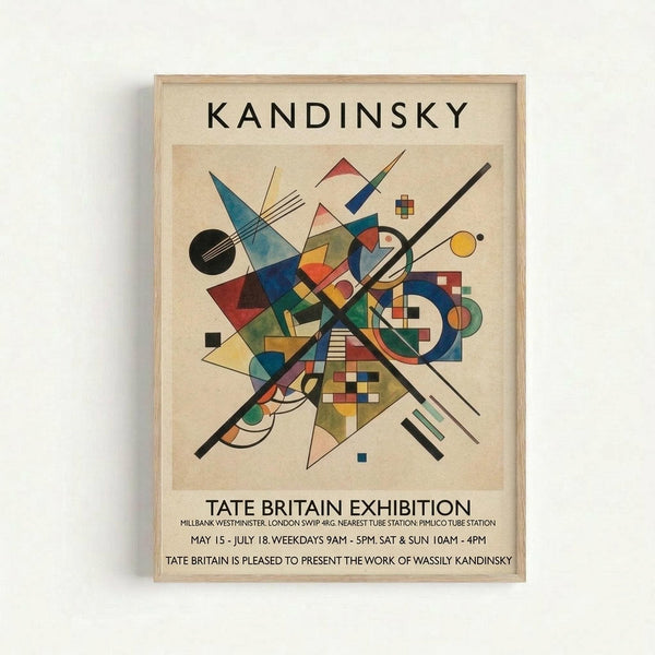 Framed abstract art print featuring Kandinsky's geometric composition with intersecting black lines, colorful triangles, circles, and squares in blue, red, yellow, and green. Exhibition poster format with "KANDINSKY" at top and "TATE BRITAIN EXHIBITION" text below the artwork. Light wood frame against white wall background.