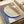 May include: Abstract art print displayed on wooden surface with cream ribbon nearby. Artwork features organic curved shapes in terracotta brown, sage green, and navy blue with white accents. Small circular moon element in upper corner. Textured brushstroke appearance with flowing, contemporary composition combining earth tones and botanical-inspired forms.