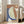 May include: Large framed abstract art print leaning against white wall next to beige sofa in bright living room. Artwork features organic curved shapes in terracotta orange, sage green, and navy blue with textured brushstroke effects and small cream circle accent on earth-toned background.