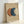 May include: Framed abstract art print featuring three overlapping circles in terracotta orange, deep blue, and cream colors on textured beige paper background. Light wood frame sits propped against white wall, casting soft shadows. Minimalist geometric design with organic, hand-painted texture visible in each circle.