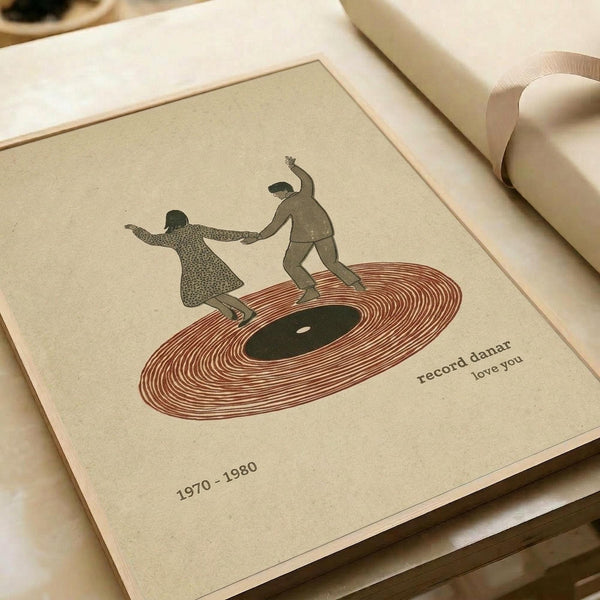 May include: Vintage-style art print on cream paper showing two silhouetted figures dancing on a red vinyl record. One figure wears a dotted pattern dress, the other solid clothing. Text reads "record danar love you" and "1970-1980" below. Print sits on white surface next to rolled papers with warm lighting creating soft shadows.