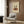 May include: Vintage-style poster artwork displayed in modern living room showing two silhouetted figures dancing on vinyl record, with cream background and rustic orange record design, text reading "record danar love you 1970-1980", hung above beige armchair with geometric pillow, brass floor lamp, and dark wood paneled wall