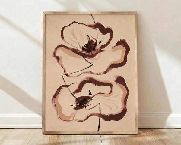 May include: Framed abstract floral artwork leaning against white textured wall on light wood floor. Two stylized poppy flowers painted in warm brown and peachy pink tones on cream background. Loose, painterly brushstrokes create organic petal shapes with dark centers and thin stems. Natural wood frame surrounds the botanical illustration in minimalist room setting with soft natural lighting.
