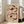 May include: Framed artwork featuring two abstract poppy flowers in earthy brown and cream tones on beige background, displayed on light hardwood floor against white wall next to beige upholstered chair with wooden legs near bright windows.