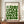May include: Framed Bauhaus-style poster with geometric green circles and semicircles arranged in a grid pattern on cream background, displayed on wooden sideboard next to white ceramic vase and stacked books in elegant room with white paneled walls