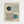 May include: Framed Bauhaus-style poster print hanging on white wall, featuring geometric design with dark green and teal blue circles intersecting curved parallel lines on cream background, text reads "BAUHAUS" at top and "Ausstellung Juli - Sept 1923" at bottom, displayed in light wood frame