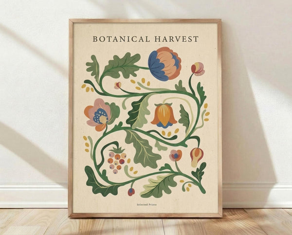 May include: Framed botanical poster with decorative floral vine design featuring stylized flowers, leaves, and berries in muted blue, coral, green and gold colors on cream background. Light wood frame leaning against white wall on wooden floor with soft natural lighting and fabric shadows.