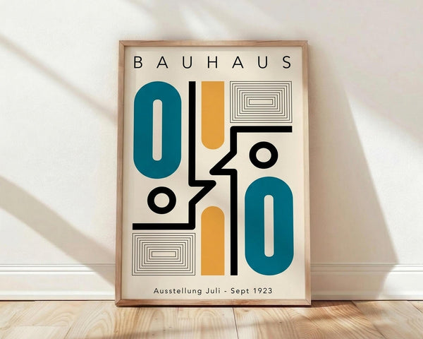 May include: Framed Bauhaus-style poster with geometric shapes in teal, orange, black and white on cream background, featuring abstract oval forms, rectangles, circles and linear patterns, displayed against white wall on wooden floor with natural lighting casting soft shadows