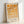 May include: Framed geometric art print featuring orange and yellow circles and semicircles arranged in a grid pattern on cream background, displayed in light wood frame leaning against white wall with soft natural lighting creating shadows