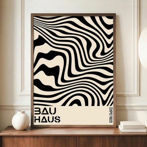 May include: Black and cream wavy striped abstract poster with "BAUHAUS" text in wooden frame, displayed on walnut sideboard next to white ceramic vase and stacked books against beige wainscoted wall in modern interior setting.