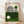 May include: Framed Bauhaus-style poster with geometric design featuring black concentric lines forming curved shapes, green and cream color blocks, small circles, and "Ausstellung Juli - Sept 1923" text, displayed on light wooden floor against white wall with natural lighting shadows
