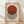 May include: A framed Bauhaus-style poster with geometric design featuring a rust-red circle overlapping a black and white striped circle on cream background, displayed in light wood frame against white wall on natural wood floor with soft shadow patterns.