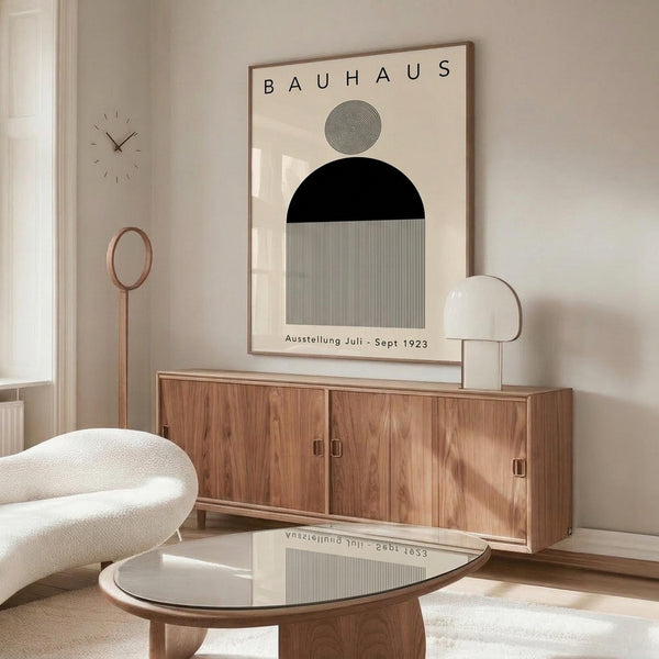 May include: Minimalist Bauhaus exhibition poster with geometric black circle, striped rectangle, and spiral design elements displayed above a wooden sideboard in modern living room setting with cream chair, glass coffee table, white lamp, and wall clock creating contemporary home decor scene