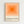 A framed poster featuring concentric orange squares in graduating shades from bright orange in the center to pale peach at the edges, displayed against a white wall. The artwork has "bauhaus-archiv" text below with "museum für gestaltung klingelhöferstrasse, berlin" in smaller print. The poster is mounted in a light wood frame with clean geometric design typical of Bauhaus style.