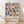 May include: Framed Bauhaus-style poster with geometric pattern of colorful circles and squares in blues, oranges, pinks, and yellows on cream background, displayed on light wooden floor against white wall with soft natural lighting and shadows