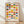 May include: Framed geometric art print leaning against white wall on light wood floor. Design features colorful semicircles in rows - blues, oranges, yellows, pinks, and greens on cream background. Text reads "BAUHAUS Est 1923" and "BAUHAUS AUSSTELLUNG WEIMAR JULI 1923" at bottom. Natural wood frame, soft window light casting diagonal shadows across textured white wall.
