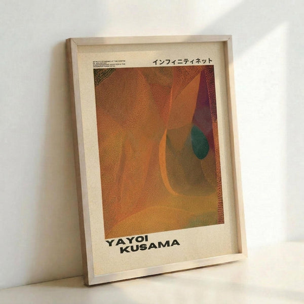 May include: Framed art print leaning against white wall showing abstract composition with warm orange, brown and purple geometric shapes plus small teal circle on textured dotted background. Japanese text appears at top, artist name at bottom in black letters on cream border. Light wood frame casts soft shadow.