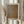 May include: Person in cream ruffle-sleeved top holding framed abstract art print featuring organic brown and tan dotted patterns. Light wood frame with white matting, Japanese text visible at top. Dried pampas grass stems held in other hand against soft neutral curtained background with natural window lighting.