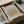 May include: Framed vintage Matisse exhibition poster featuring golden botanical motifs on beige background, displayed in wooden frame inside cardboard shipping box with tissue paper packaging on white surface