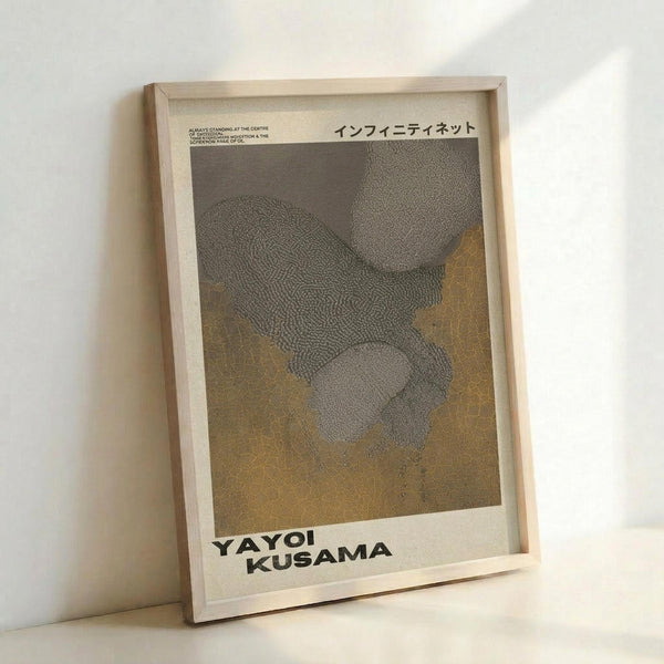 May include: Framed art print leaning against white wall corner showing abstract dotted pattern in gray and golden yellow tones. Japanese text at top, artist name at bottom. Natural wood frame with white matting. Textured dotted design creates flowing, organic shapes across the composition.
