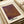 May include: Abstract art print with textured purple and orange gradient background featuring dotted pattern, displayed in cream-colored frame on wooden surface alongside rolled paper tubes. The artwork shows organic flowing lines with stippled texture transitioning from deep purple at top to warm amber tones below.