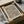 May include: Abstract art print with flowing black linear waves pattern on cream paper, displayed in black frame inside cardboard shipping box with white tissue paper. Wooden dowels and glass vessel visible nearby. Minimalist topographic-style design with organic curved lines creating undulating surface effect.