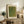 May include: Framed green textured art print with polka dot pattern and Japanese text displayed on rustic wooden sideboard next to fern plant, ceramic vases, and books in neutral-toned living room setting