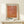 May include: Framed art print with orange abstract dotted pattern and Japanese text, displayed on light wood console table against cream wall. Small wrapped gift box with greenery sits beside the natural wood frame. Warm, minimalist home decor styling with soft natural lighting creating gentle shadows.