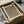 May include: Framed beige and brown textured art print in wooden frame, displayed in unboxing scene with cardboard packaging, wooden dowels, and white tissue paper on neutral surface. The artwork features subtle dotted pattern with Japanese characters in corner.